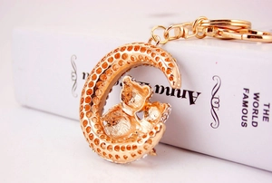 Close-up of golden moon and bear keychain with sparkling rhinestones and hollow texture