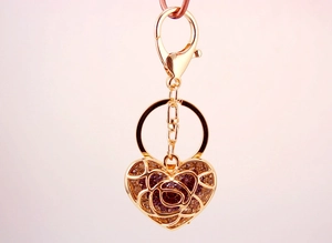 Detail of heart keychain with gold plating, purple crystals and lobster clasp