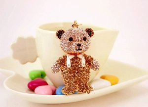 Détail d'un pendentif ours en peluche serti de cristaux avec un nœud papillon élégant