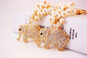 Close-up of golden elephant keychain with sparkling rhinestones and white pearl cluster