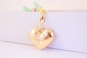 Detailed view of the 3D gold heart keychain with intricate textured metal surface