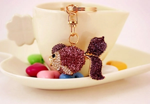 Detailed macro view of goldfish keychain with purple rhinestones and golden finish