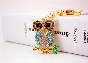 Detailed view of colorful owl keychain with rhinestones and green enamel leaf detail