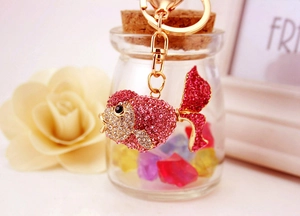 Detail of goldfish keychain with pink and white rhinestones on a glass jar