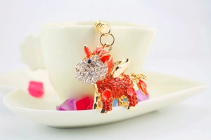 Detail view of unicorn keychain with sparkling red and white rhinestones on golden metal