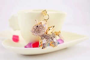 Detail of a sparkling unicorn keychain with white rhinestones and golden wings