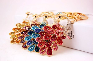 Close-up of colorful peacock keychains with sparkling rhinestones and gold alloy rings