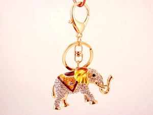 Gros plan du porte-clés éléphant doré avec strass brillants et émail multicolore