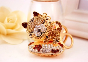 Vista macro di un portachiavi a forma di gatto dorato con strass brillanti e chiusura