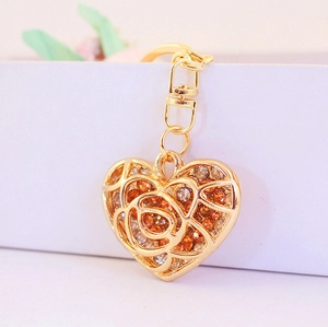 Golden heart-shaped keychain with rose pattern, hollow design and sparkling rhinestones