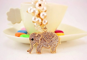 Detail of crystal elephant keychain with white imitation pearls and gold finish