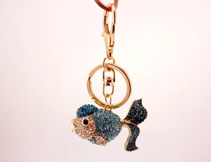 Macro shot of a goldfish keychain featuring sparkling blue and champagne rhinestones