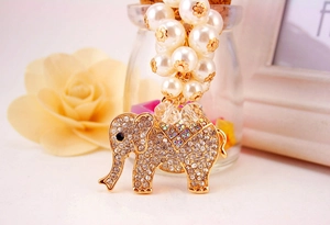 Macro detail of elephant keychain with sparkling crystals and elegant white pearls