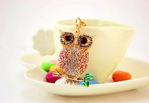 Close-up of colorful rhinestone owl keychain with green glazed branch detail