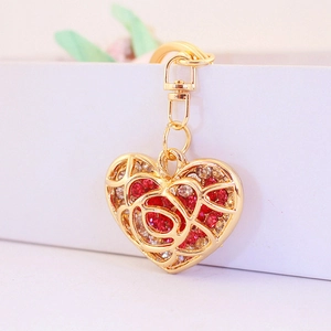 Creative hollow heart keychain with red rhinestones and rose pattern in gold finish