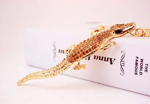 Detailed view of crocodile keychain featuring amber rhinestones on gold alloy base