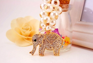 Detailed close-up of golden elephant keychain with sparkling rhinestones and white pearls