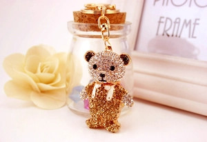 Vue détaillée du porte-clés ours en strass brillant avec fermoir doré et nœud papillon