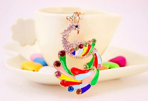 Macro shot of colorful peacock keychain with enamel feathers and inlaid crystals