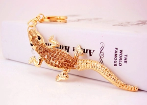 Detail of crystal-studded gecko keychain with gold-plated metal and brown rhinestones