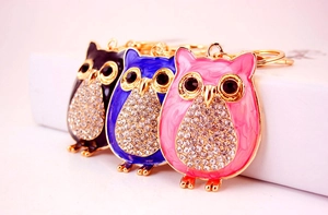 Détail macro de porte-clés hibou en émail avec cristaux colorés et base en métal doré