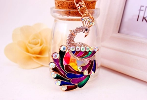 Close-up of colorful peacock keychain with sparkling crystals and enamel details