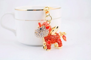 Detail of cute rhinestone unicorn keychain with red crystals and gold hardware on cup