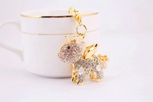 Macro shot of a gold unicorn keychain with white rhinestones on a ceramic cup