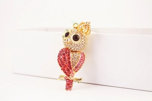 Vue détaillée du porte-clés hibou avec strass rouges et blancs sur alliage doré