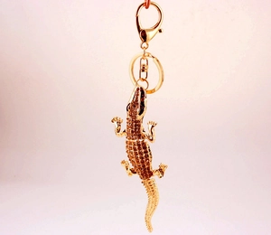 Close-up of golden alligator keychain with sparkling rhinestones and lobster clasp