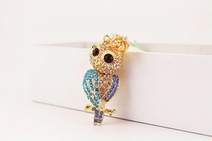 Détail du porte-clés hibou avec strass étincelants, couronne et cristaux bleus