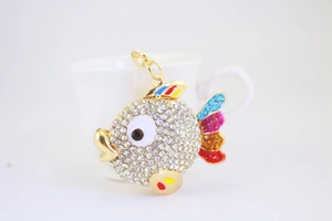 Detailed close-up of a golden tropical fish keychain with sparkling white rhinestones