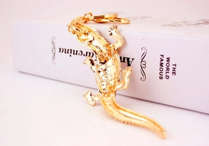 Detailed view of a golden crocodile keychain with sparkling rhinestones on an alloy frame