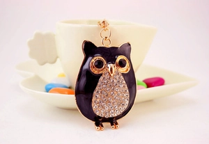 Détail du porte-clés hibou avec émail noir, cadre doré et accents de cristal brillant