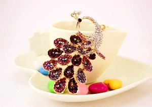 Detailed close-up of peacock keychain featuring purple rhinestones and colorful crystals
