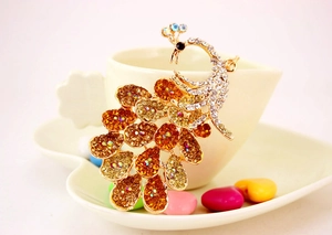Macro shot of colorful rhinestones on a gold-plated peacock keychain with crystal details