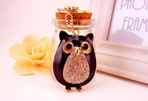 Détail du porte-clés hibou avec émail noir, cadre doré et cristaux scintillants