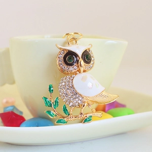 Exquisite owl keychain with white rhinestones and green crystal eyes on gold branch