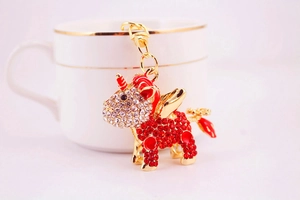 Detail shot of a winged unicorn keychain with red and white rhinestones on a coffee cup