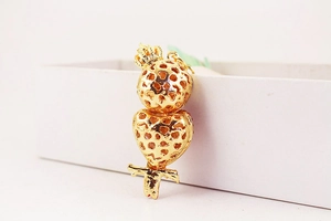 Gros plan d'un porte-clés hibou doré avec motif de cœur évidé et couronne