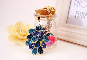 Macro shot showing blue crystal rhinestones on the peacock keychain with a gold finish