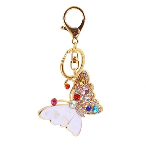 Détails de porte-clés papillon avec strass colorés et ailes nacrées sur fond blanc