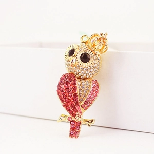 Porte-clés chouette étincelant avec couronne, dorure et strass colorés sur fond blanc