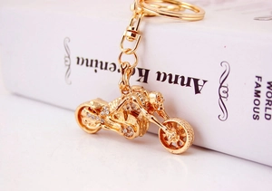 Detail of vintage gold motorcycle keychain with skull rider and sparkling crystal rhinestones