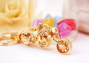 Macro shot of gold motorcycle skull keychain with shiny rhinestones and punk metal finish