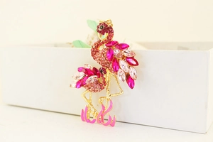 Makroaufnahme von goldfarbenem Flamingo-Schlüsselanhänger mit Strass und Emaille