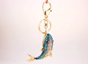 Detailed close-up of a sparkling shark keychain with blue rhinestones and gold lobster clasp