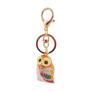 Detail view of golden owl keychain with colorful enamel inlay and sparkling rhinestones