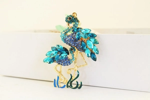 Makroaufnahme Flamingo-Anhänger mit blauen Strasssteinen und goldener Fassung