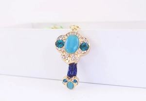 Detail of Ruyi jewelry pendant with light blue cat eye stone and golden crystal inlay